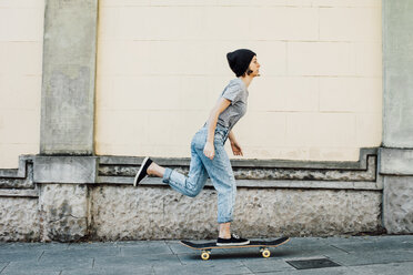 Young female skate boarder driving with her skateboard - EBSF000299