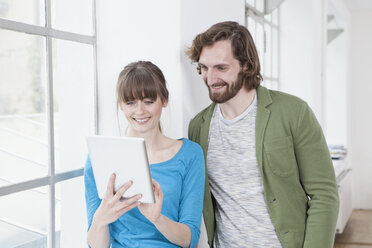 Two colleagues looking at digital tablet in a creative office - RBF001786