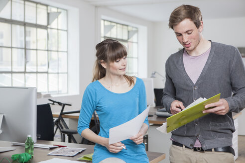 Two colleagues in an office discussing something - RBF001789