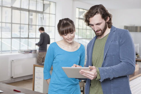 Two colleagues in a creative office using digital tablet - RBF001733