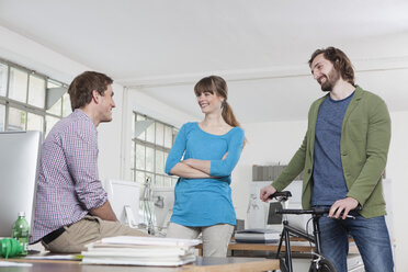 Three colleagues talking together in an office - RBF001749