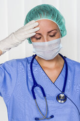 Exhausted doctor in surgical gown - EJWF000461