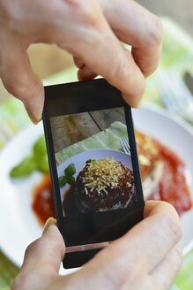 Mann, der ein Gericht, gefüllte Portobello-Pilze, mit einem Smartphone fotografiert - HAWF000426