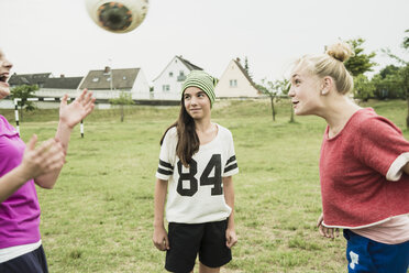 Drei Mädchen im Teenageralter spielen Fußball auf einem Fußballplatz - UUF001587