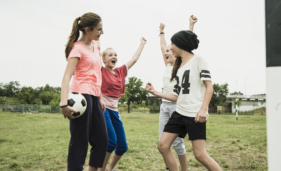 Four teenage girls having fun on a soccer field - UUF001556