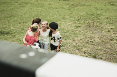 Vier Freundinnen im Teenageralter haben Spaß auf einem Fußballplatz, Blick von oben - UUF001562