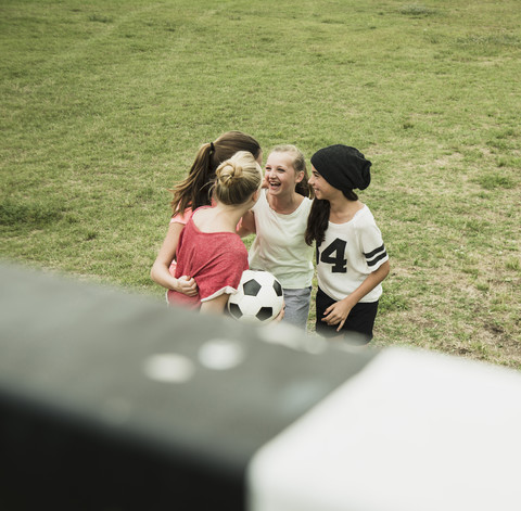 Four female teenage friends having fun on a soccer field, elevated view stock photo