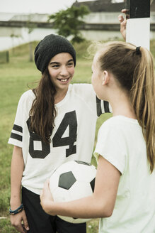 Zwei Mädchen im Teenageralter kommunizieren auf einem Fußballplatz - UUF001568