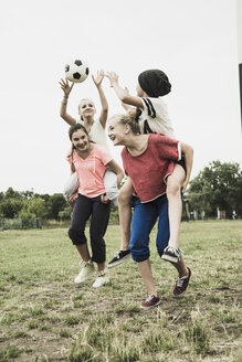 Vier Mädchen im Teenageralter haben Spaß auf einem Fußballplatz - UUF001575