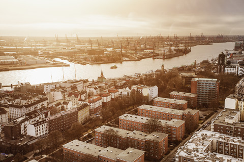 Deutschland, Hamburg, St. Pauli mit Hamburger Hafen, Elbe bei Sonnenuntergang, lizenzfreies Stockfoto