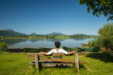 Germany, Bavaria, Allgaeu, East Allgaeu, Lake Hopfensee, near Fuessen, Mature woman sitting on wodden bench - WGF000410