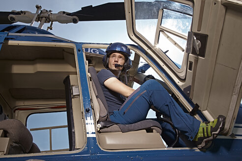 Germany, Bavaria, Landshut, Helicopter pilot sitting in open helicopter, waiting - KDF000070