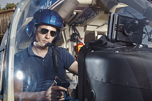 Germany, Bavaria, Landshut, Helicopter pilot in cockpit - KDF000042