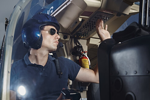 Germany, Bavaria, Landshut, Helicopter pilot in cockpit - KDF000043