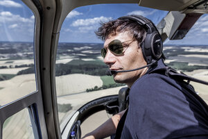 Deutschland, Bayern, Landshut, Hubschrauberpilot im Cockpit - KDF000048