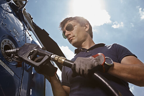 Germany, Bavaria, Landshut, Helicopter pilot refuelling aircraft - KDF000071