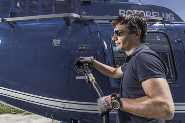 Germany, Bavaria, Landshut, Helicopter pilot refuelling aircraft - KDF000073