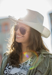 Porträt eines lächelnden Teenagers mit Sonnenbrille und weißem Hut - UUF001595