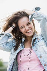 Porträt eines lachenden Teenagers mit den Händen in den Haaren - UUF001610