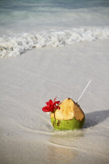 Seychelles, Praslin Island, Coconut with straw at the beach - KRPF000724