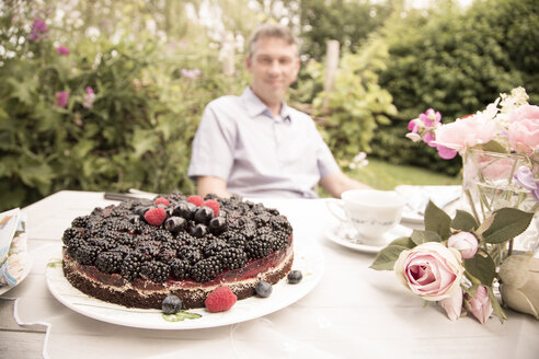 Schokoladenbeerenkuchen auf einem Gartentisch - FCF000401