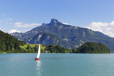 Austria, Upper Austria, Salzkammergut, View of sailing boat in Mondsee Lake, Schafberg in the background - SIEF005754