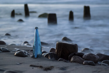 Germany, Mecklenburg-Western Pomerania, Ruegen, Message in a bottle at beach - PA000735