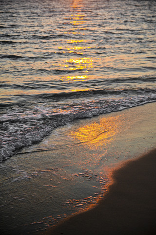 Griechenland, Sonnenlicht spiegelt sich auf dem Wasser am Strand, lizenzfreies Stockfoto