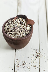 Earthenware dish of organic quinoa, Chenopodium quinoa, on white wood - SBDF001160