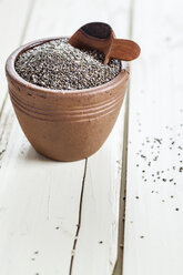 Earthenware dish of organic black chia, Salvia hispanica, on white wood - SBDF001162