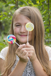 Portrait of girl holding lollipops - YFF000213