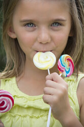 Portrait of girl holding lollipops - YFF000214