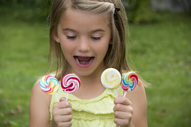 Portrait of girl holding lollipops - YFF000216
