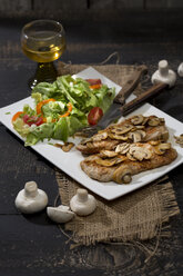 Fried schnitzel with mushrooms and salad on plate - MAEF008965