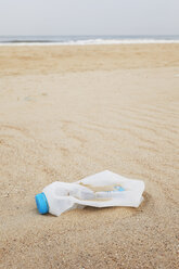 Belgien, leere Plastikflasche am Sandstrand an der Nordseeküste - GWF003127