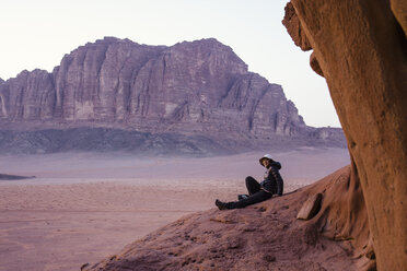 Jordanien, Japanerin sitzt auf einem Felsen im Wadi Rum - FLF000496