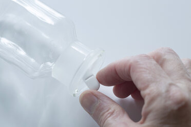 Woman taking a pill from tablet jar - SGF000832