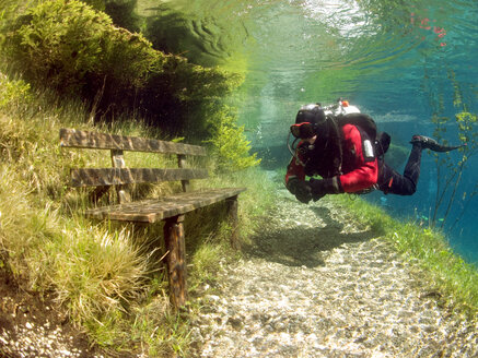 Austria, Styria, Tragoess, lake Gruener See, diver in front of a park bench - YRF000050