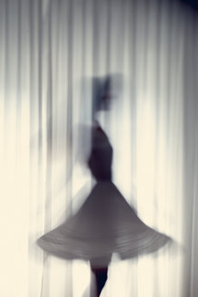 Silhouette of a young woman dancing in front of a white curtain - BRF000577