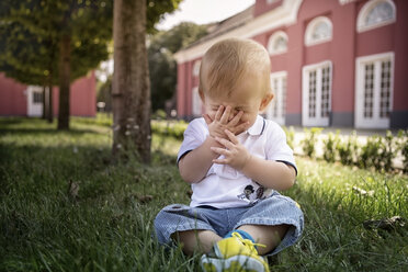 Germany, Oberhausen, Blond baby boy sitting in park of Oberhausen Castle - GDF000403