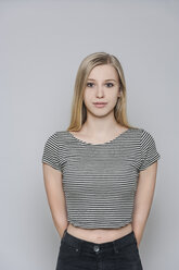 Porträt einer jungen blonden Frau mit Händen hinter dem Rücken - TCF004101