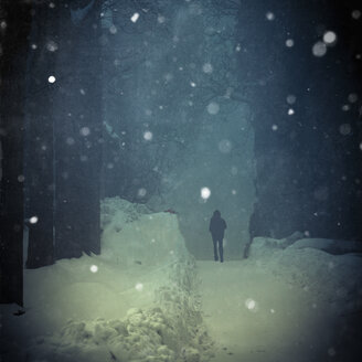 Mann geht in der Winterdämmerung bei Schneefall, digitale Bearbeitung - DWI000160