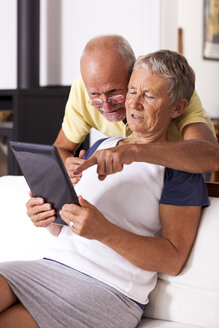 Senior couple at home using digital tablet - JUNF000005
