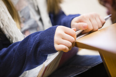 Die Hand einer Schülerin hält ein Schulbuch, Nahaufnahme - DISF000983