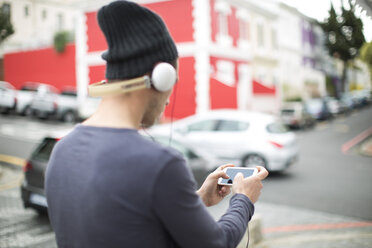 Junger Mann mit Kopfhörern und Smartphone hört Musik - ZEF000030