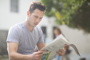 Porträt eines jungen Mannes, der eine Zeitung liest - ZEF000073