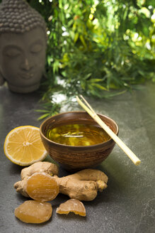 Ginger lemon tea in a tea bowl with fresh lemongrass, candied and fresh ginger - CSTF000390