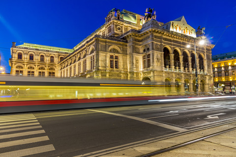 Österreich, Wien, Blick auf die Staatsoper in der Dämmerung mit fahrender Straßenbahn im Vordergund, lizenzfreies Stockfoto