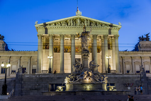 Österreich, Wien, Blick auf beleuchtetes Parlamentsgebäude und Brunnen mit Statue der Göttin Pallas Athene im Vordergrund - EJWF000534