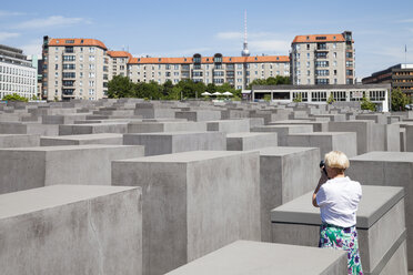 Germany, Berlin, Holocaust Memorial, Mature woman photographing steles - WIF000946